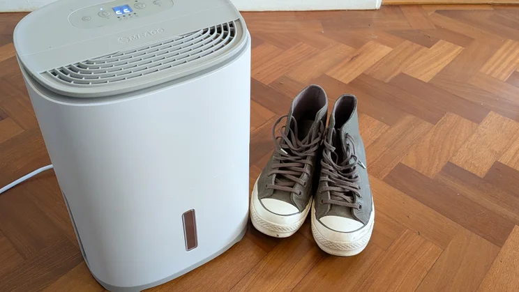 The Meaco Arete One 6L dehumidifier on a hardwood floor alongside a pair of shoes