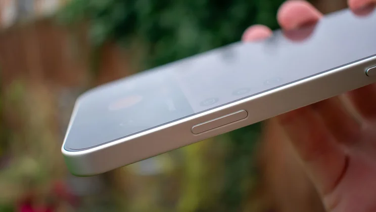 Oppo Find X9 Pro in hand, showing the camera control button