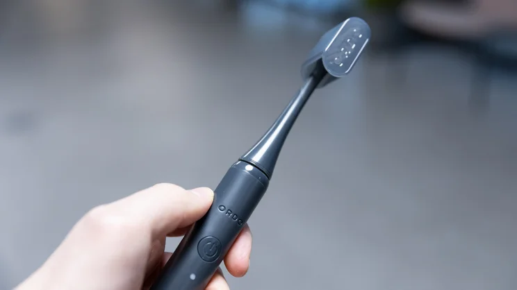 The Ordo Sonic Edge toothbrush, with travel cap on, in a hand
