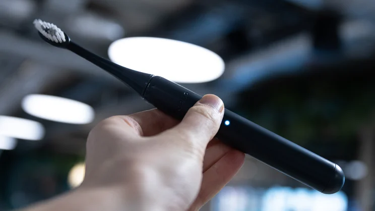 The Ordo Sonic Edge toothbrush, switched on, in a hand