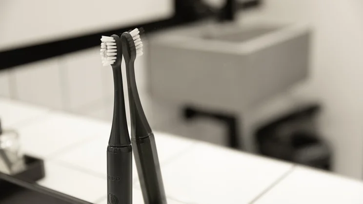 The Ordo Sonic Edge toothbrush stood up against a bathroom mirror