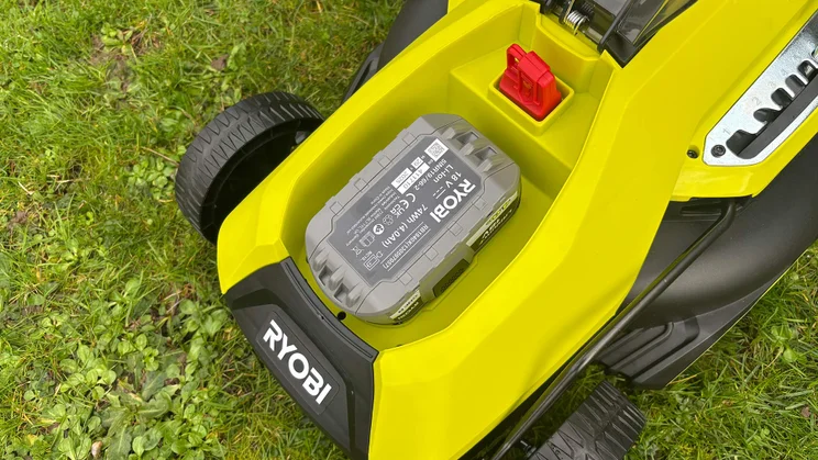 The Ryobi RY18LMX33A lawn mower's battery, in its housing