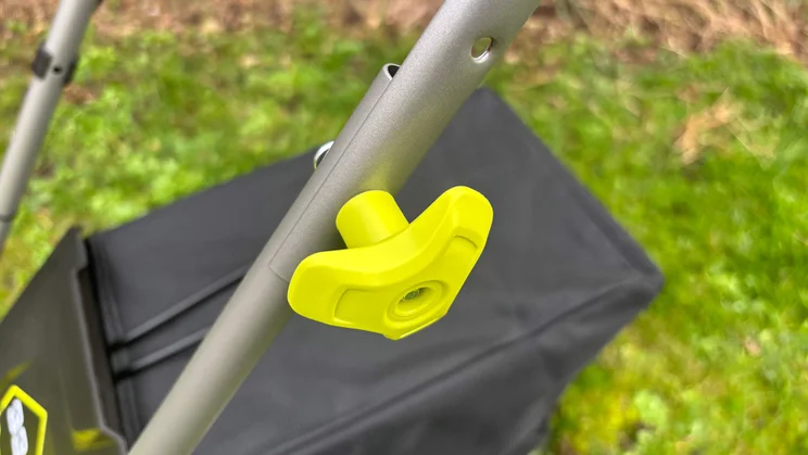 A closeup of the Ryobi RY18LMX33A lawn mower's handle adjustment knob