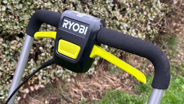 A closeup of the Ryobi RY18LMX33A lawn mower's handle