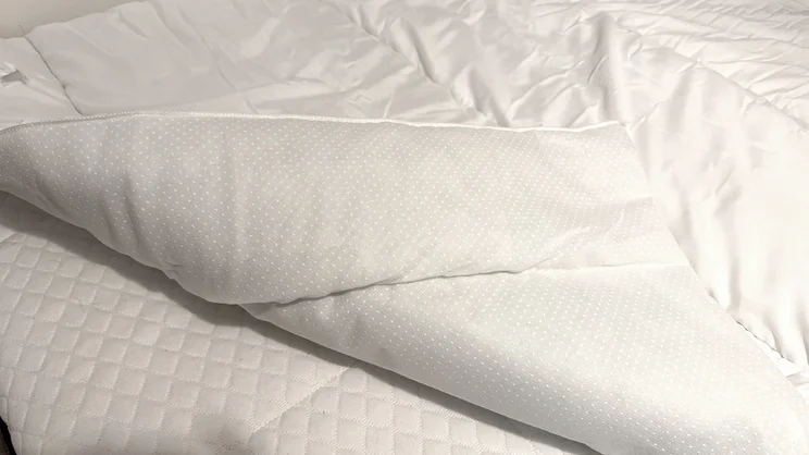 A closeup of the Slumberdown Sleep Soundly Climate Control mattress topper, with its corner folded over