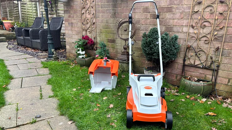 The Stihl RMA 235 lawn mower with grass collector removed and placed behind it