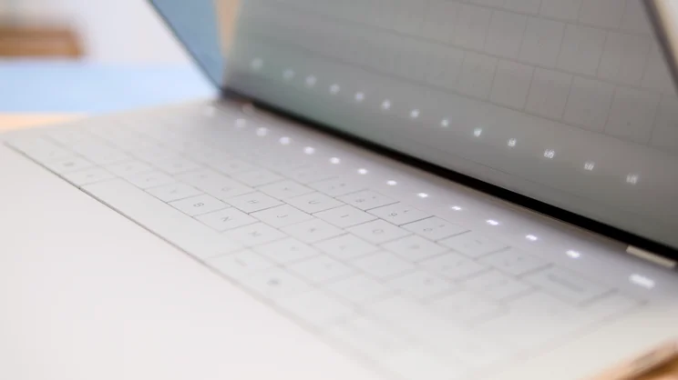 The Dell 14 Premium, half open, with the touchbar LEDs lit up