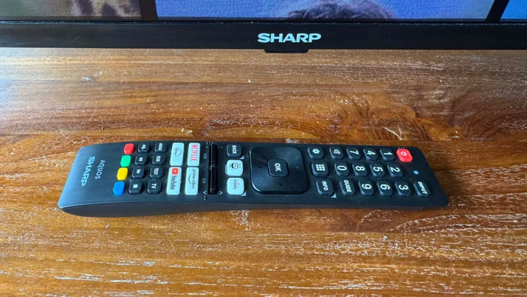 The remote control included with the Sharp GK4245K TV laid down horizontally in front of the Sharp GK4245K TV