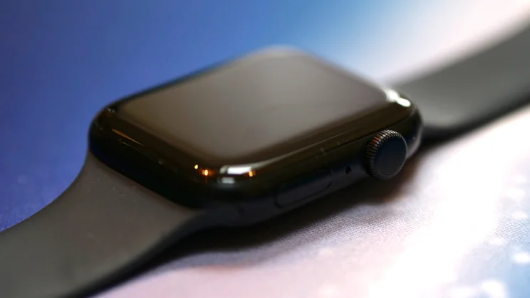 Apple Watch SE 3 lying flat on a blue and white mat with screen off