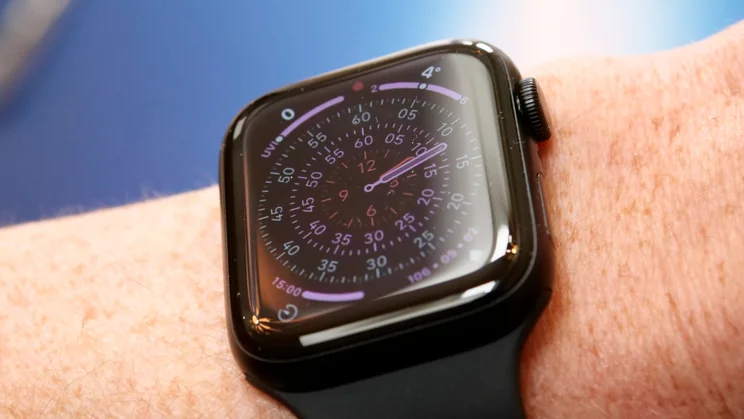 Apple Watch SE 3 on wrist with a blue background