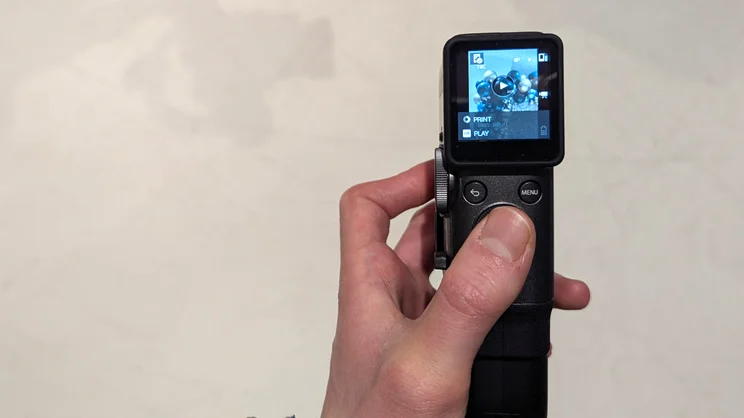 A POV of the Instax Mini Evo Cinema in use, using the controls to cycle through clips