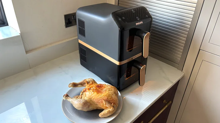 The Philips 4000 Series Stacked Dual Basket Air Fryer on a kitchen worktop, alongside a cooked chicken