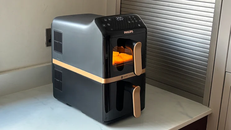 Hash browns cooking in the Philips 4000 Series Stacked Dual Basket Air Fryer, on a kitchen worktop