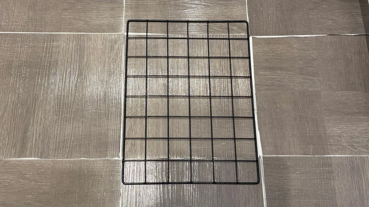 A sample of vinyl flooring, with a square grid on top of it