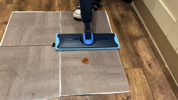 The Philips OneUp mop being used on a sample of vinyl flooring to clean a ketchup stain