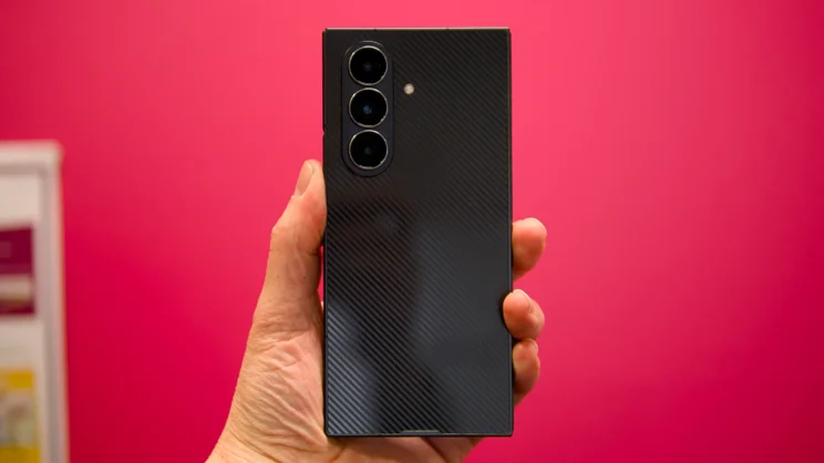 The Samsung Galaxy Z TriFold, folded, pictured from the rear, against a pink background