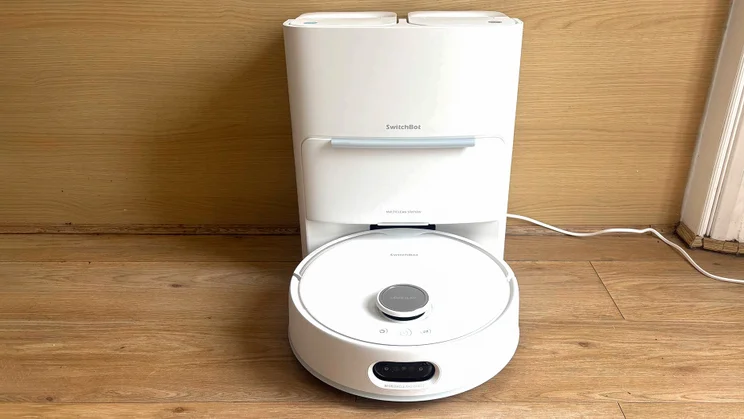 The Switchbot S20 robot vacuum in its docking base