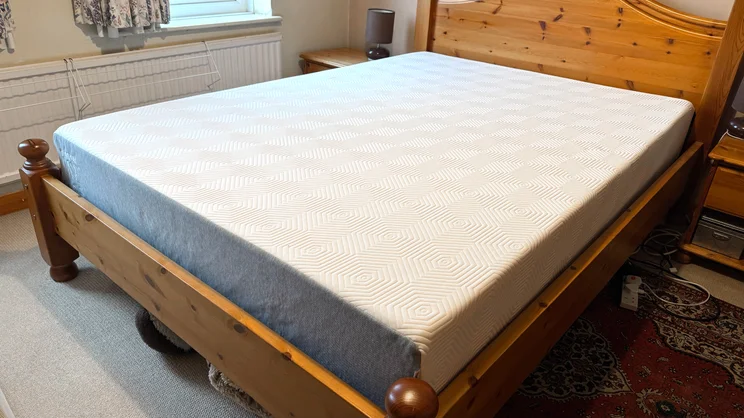 The TEMPUR EASE mattress on a wooden bed frame in a bedroom