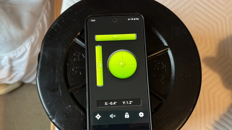 Testing tilt at the edge of the TEMPUR EASE mattress, using a series of weights and a smartphone