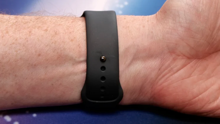 The Apple Watch SE 3's sports loop silicone rubber wristband showing the clasp mechanism