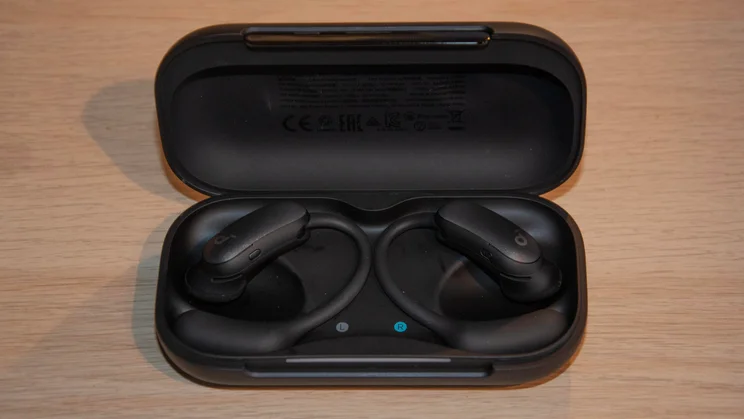 The Anker Soundcore AeroFit 2 Pro in their charging case with the lid open