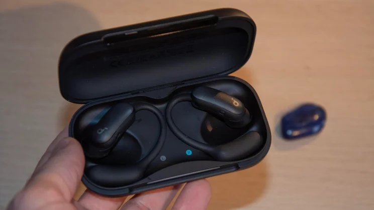 The Anker Soundcore AeroFit 2 Pro charging case open being held in a hand