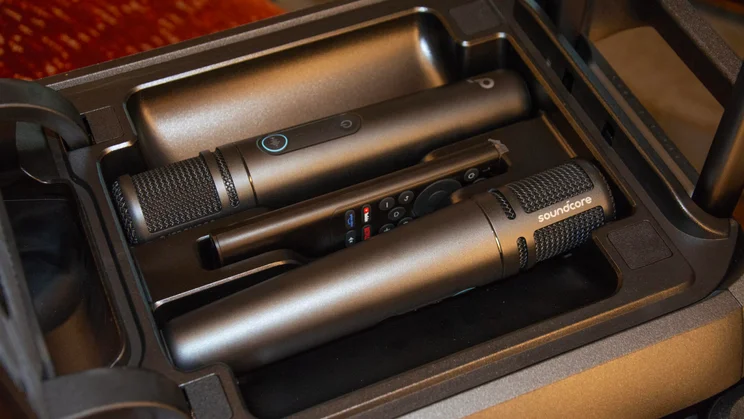 The two microphones and remote control included with the Anker Soundcore Nebula X1 Pro