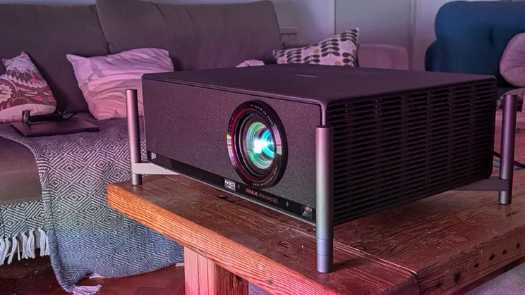 The XGIMI Titan projector on a wooden table in a dark room