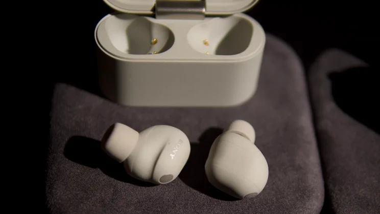 A close up of the Sony WF-1000XM6 earbuds, pictured next to their case