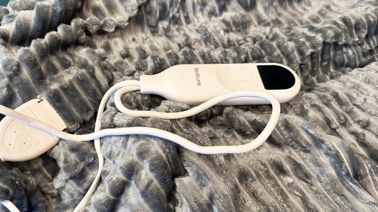 A closeup of the Bedsure Heated Blanket Electric Throw's controls and cable