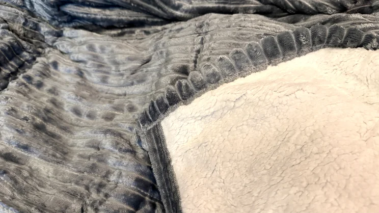 A closeup of the Bedsure Heated Blanket Electric Throw's sufrace and underside