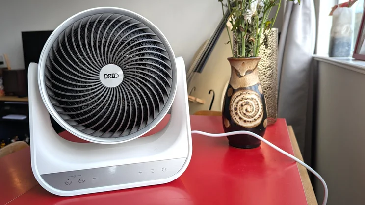 A back view of the Dreo Smart Whole Room Heater 714s on a red table in a living room