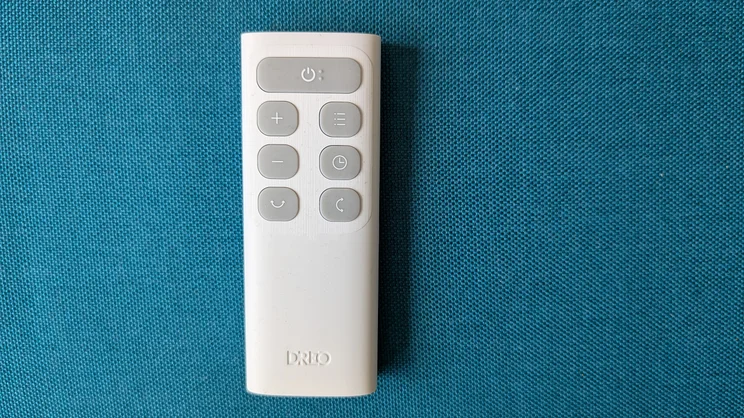 A bird's eye view of the Dreo Smart Whole Room Heater 714s remote control, on a blue background