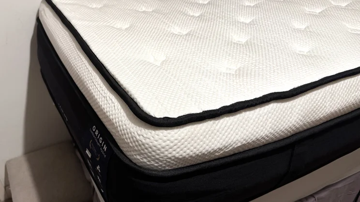 A corner of the Origin LumbarCloud mattress, on a bedframe