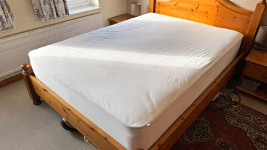 The Panda Bamboo mattress protector on a bed, in a well-lit bedroom
