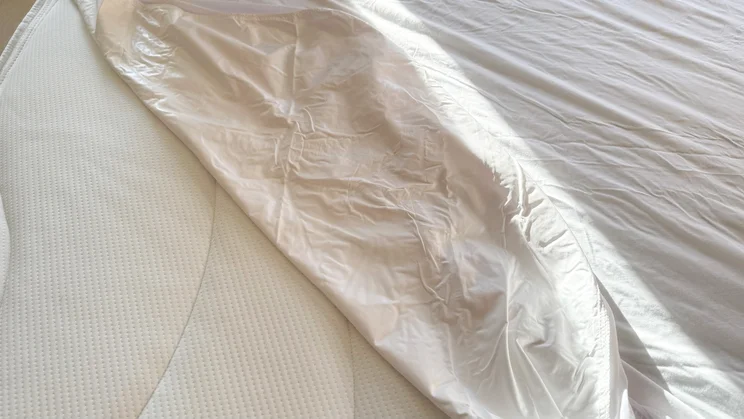 A closeup of the Panda Bamboo mattress protector, partially covering a mattress