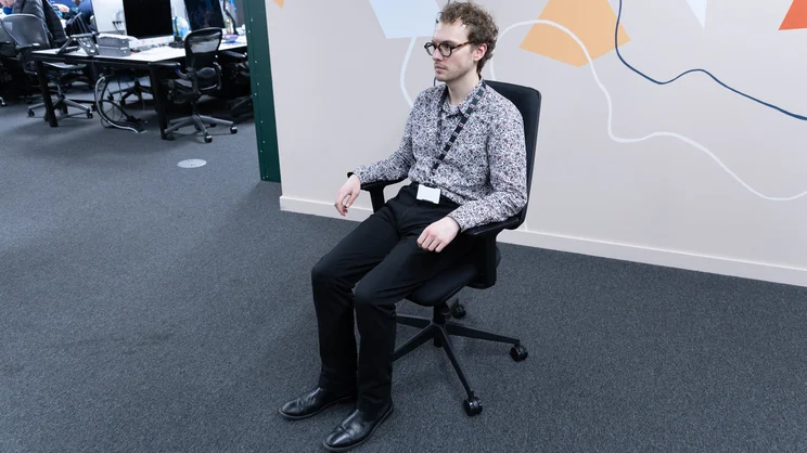 Viewed from the front, a person sits in the Posturite Homeworker Plus office chair