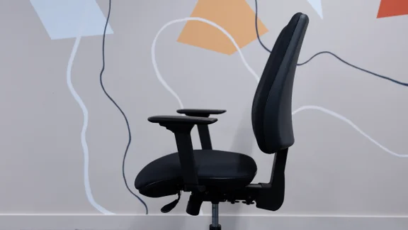 The Posturite Homeworker Plus office chair viewed from the side, in an office against a wall