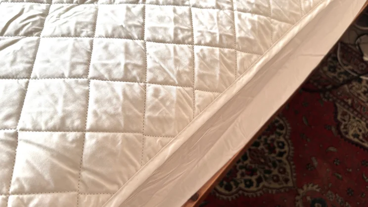 A closeup of the Scooms 100% Pure Cotton mattress protector, on a mattress