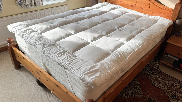 The Slumberdown Sleep Soundly Extra Deep Climate Control mattress topper on a mattress and bed, in a well-lit bedroom