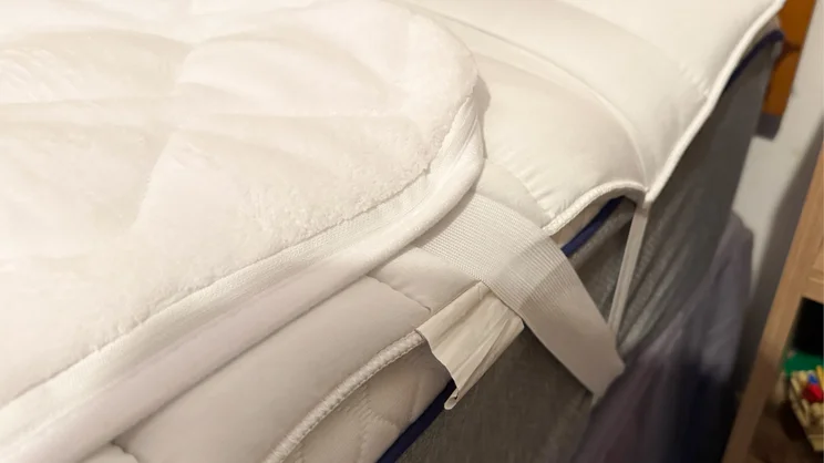 A closeup of the Slumberdown Wonderfully Warm Electric Blanket's elasticated strap, holding it to a mattress