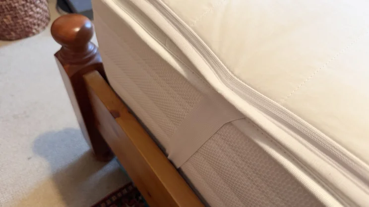 A closeup of the side of the Snuggledown Intelligent Warmth electric blanket, showing one of its elasticated straps holding it in place