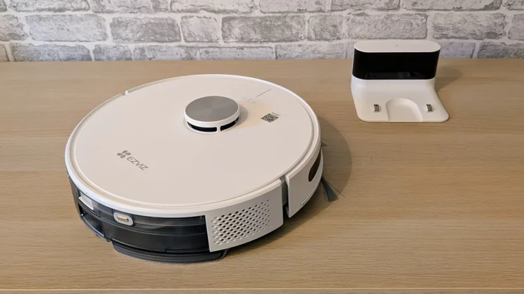 The EzViz RE4 robot vacuum pictured from above next to its charging station