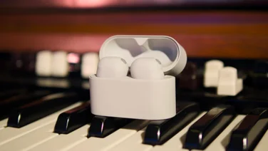 The Sony WF-1000XM6 in their charging case on a music keyboard