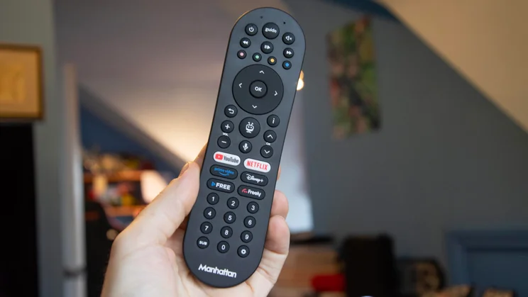 The remote control included with the Manhattan Aero 4K TV Streamer with Freely being held in a hand