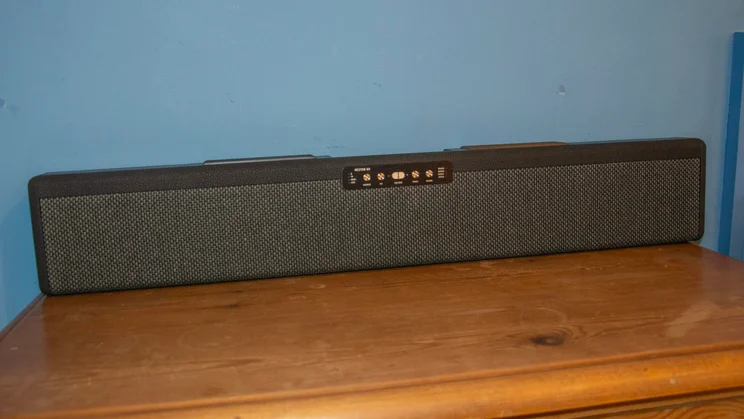 The Marshall Heston 60 soundbar against a blue wall in its wall-mount orientation