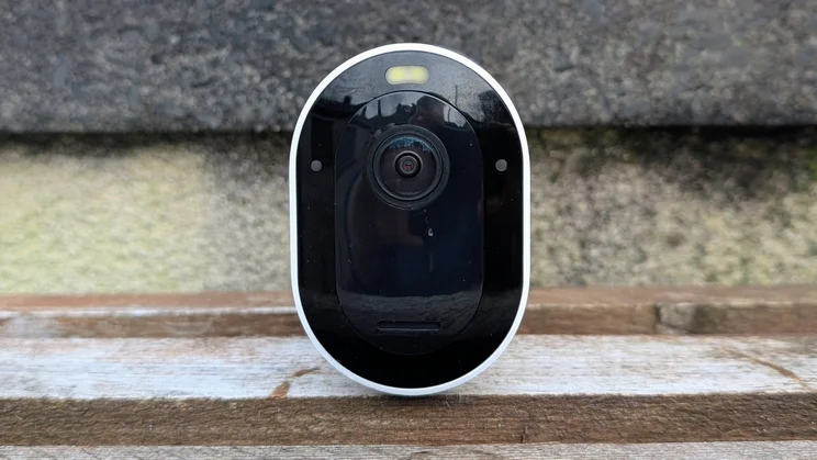 Arlo Pro 6, pictured on a wood shelf from the front