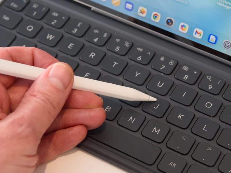 A photograph of someone holding the Honor MagicPad 4's stylus