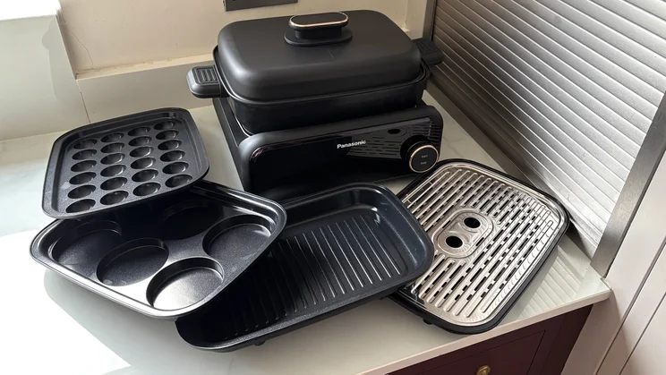 The Panasonic 6-in-1 Table-top Multi Cooker and its different cooking plates on a kitchen surface