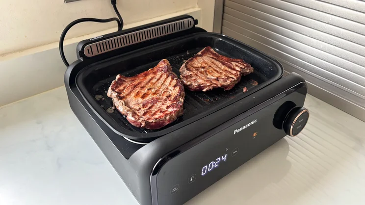 Steak cooking on the Panasonic 6-in-1 Table-top Multi Cooker's griddle plate